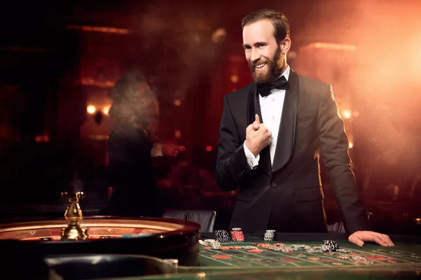 A woman smiling while playing online games on her laptop, surrounded by neon casino elements, showcasing 86JLPH’s diverse game collection.